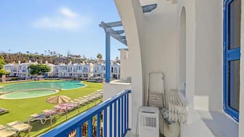 Ein Balkon mit Pool, Liegestühlen und Blick auf eine Wohngegend.