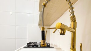 Ein Badezimmer mit einem modernen Wasserhahn, einem Waschbecken und einer Duschbrause.