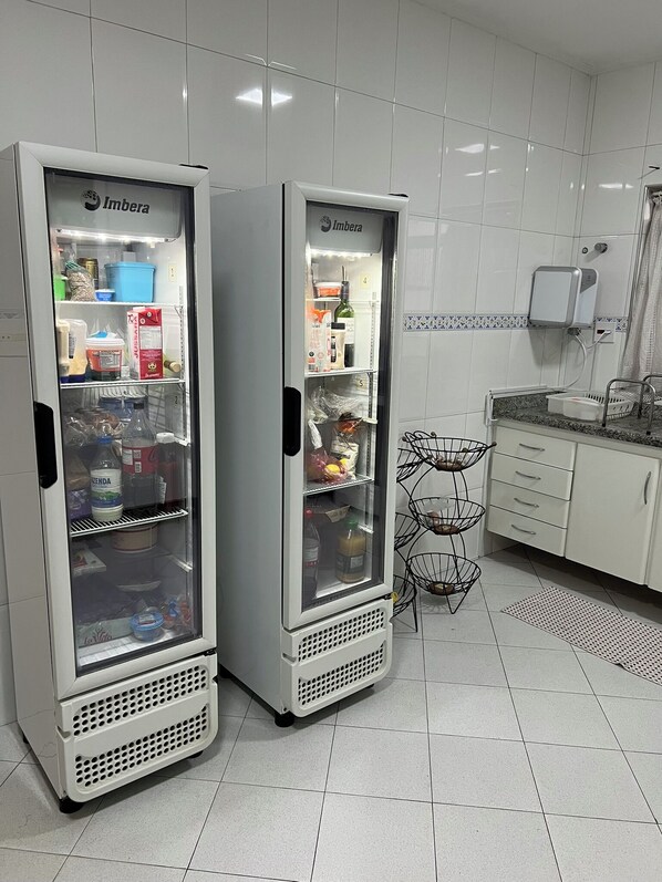 Two Imbera vending machines in a clean, tiled kitchen area with a metal rack and a small sink.