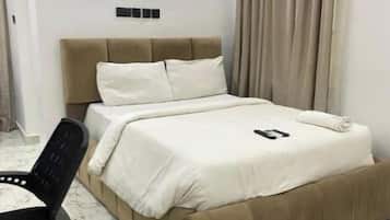 Een slaapkamer met een bed, een stoel en een marmeren vloer.