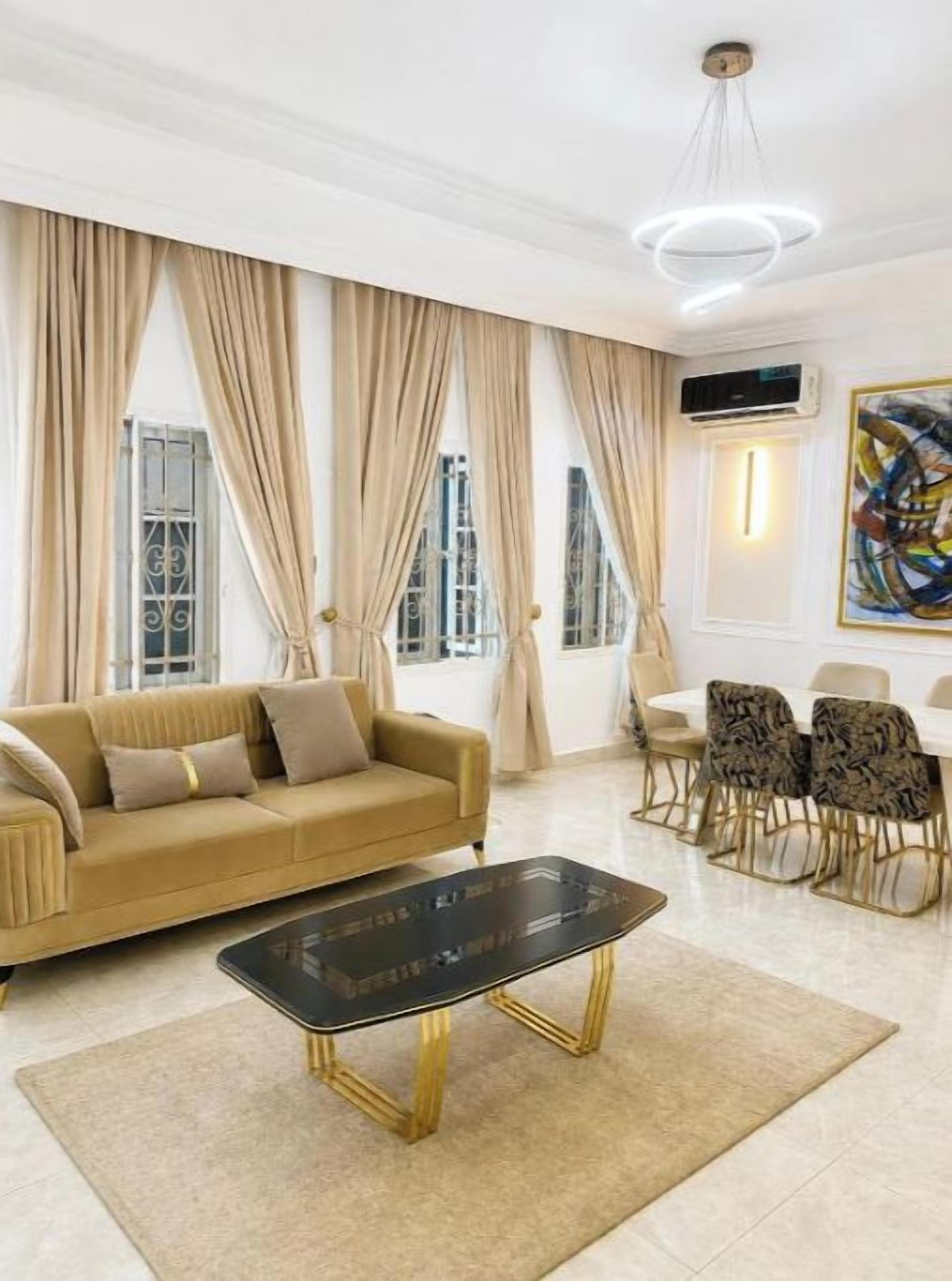 A living room with a sofa, coffee table, and dining area with chairs.