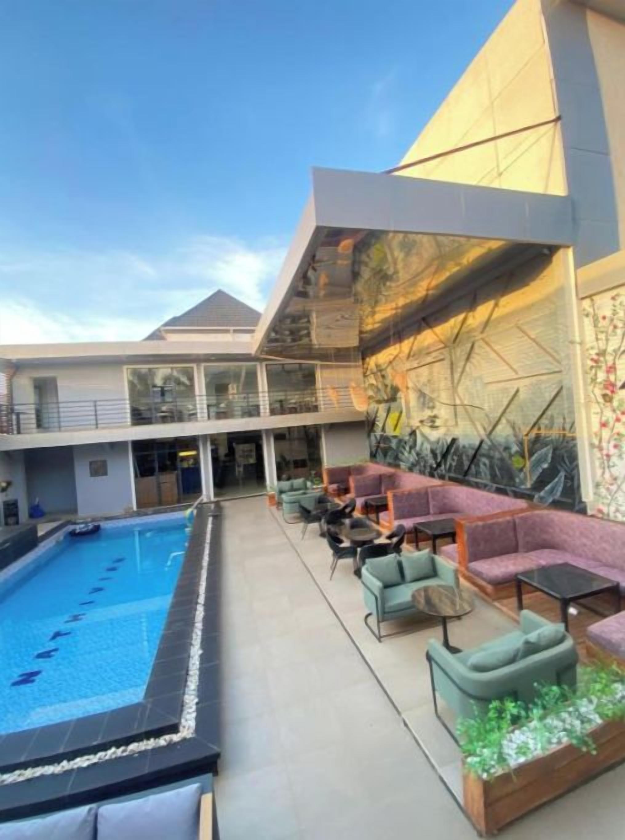 A rooftop pool area with seating and a covered section.
