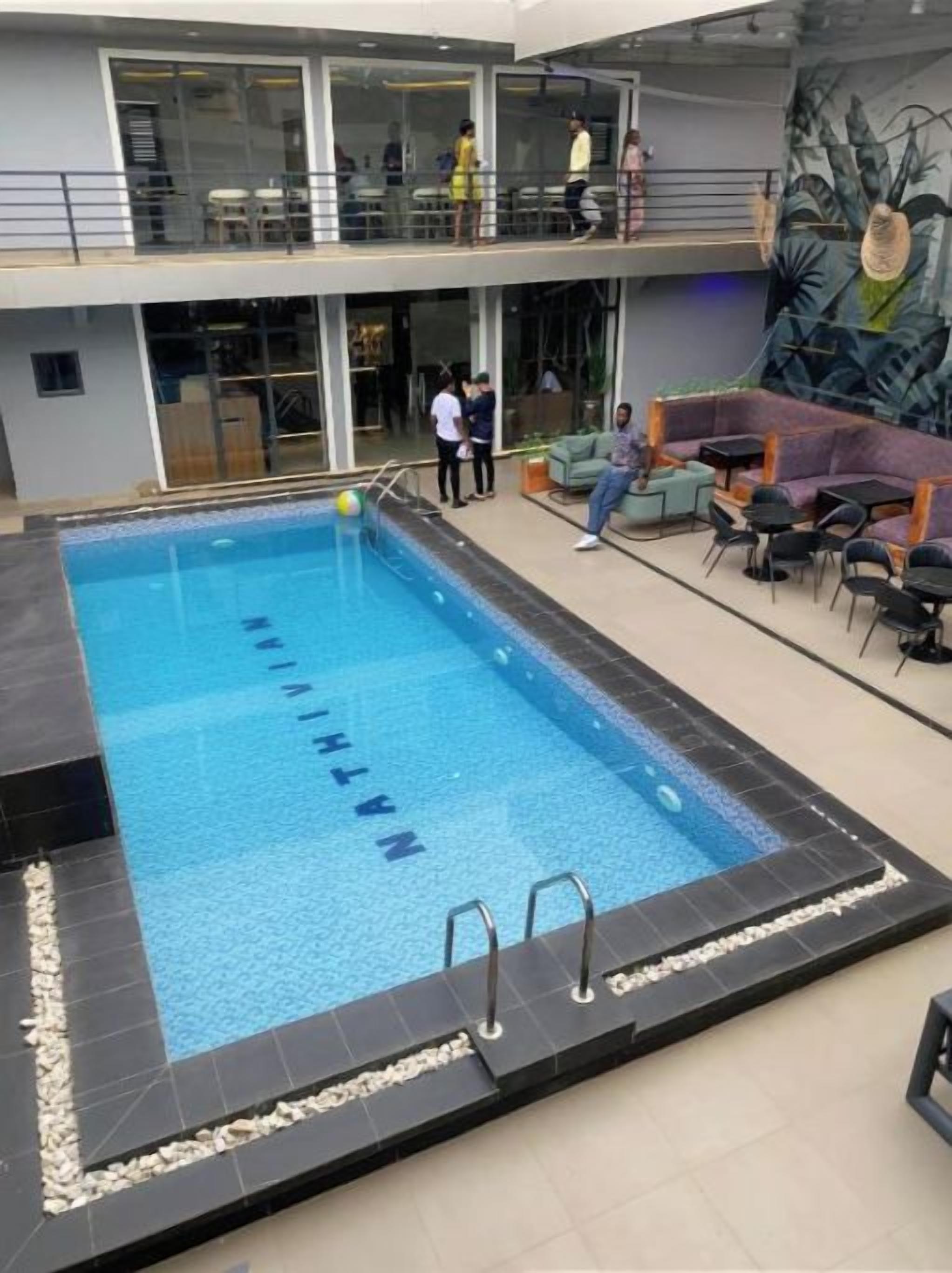Ein beheiztes Hallenbad mit glasklarer Wasserfläche, umgeben von einer gefliesten Liegefläche.