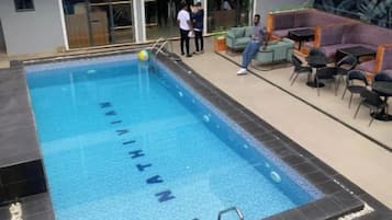 Ein beheiztes Hallenbad mit glasklarer Wasserfläche, umgeben von einer gefliesten Liegefläche.