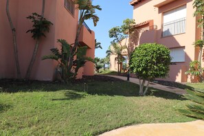 A residential area with a well-maintained lawn, palm trees, and a clear sky. - Doowrevlis 2 bedroom apt Mar Menor Golf (Torre Pacheco)