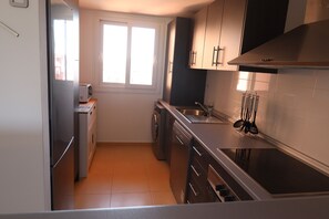 A compact kitchen with a built-in oven, a microwave, and a dishwasher. - Doowrevlis 2 bedroom apt Mar Menor Golf (Torre Pacheco)