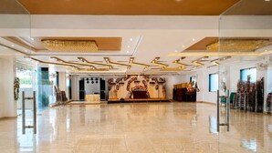 Un amplio salón con un escenario, asientos y un decorado.