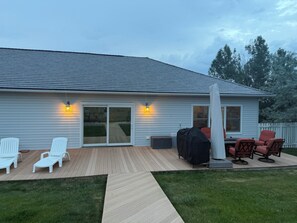 A house with a covered patio, outdoor seating, and a grill. - Spacious 5-bedroom house in beautiful Gillette with AC (Gillette)