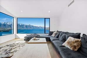 A modern living room with a large window offering a mountain view. - Aspen Ridge by MajorDomo | Fernhill Villa with Lake Views, Infrared Sauna, Spa Pool & Outdoor Fireplace (Queenstown)