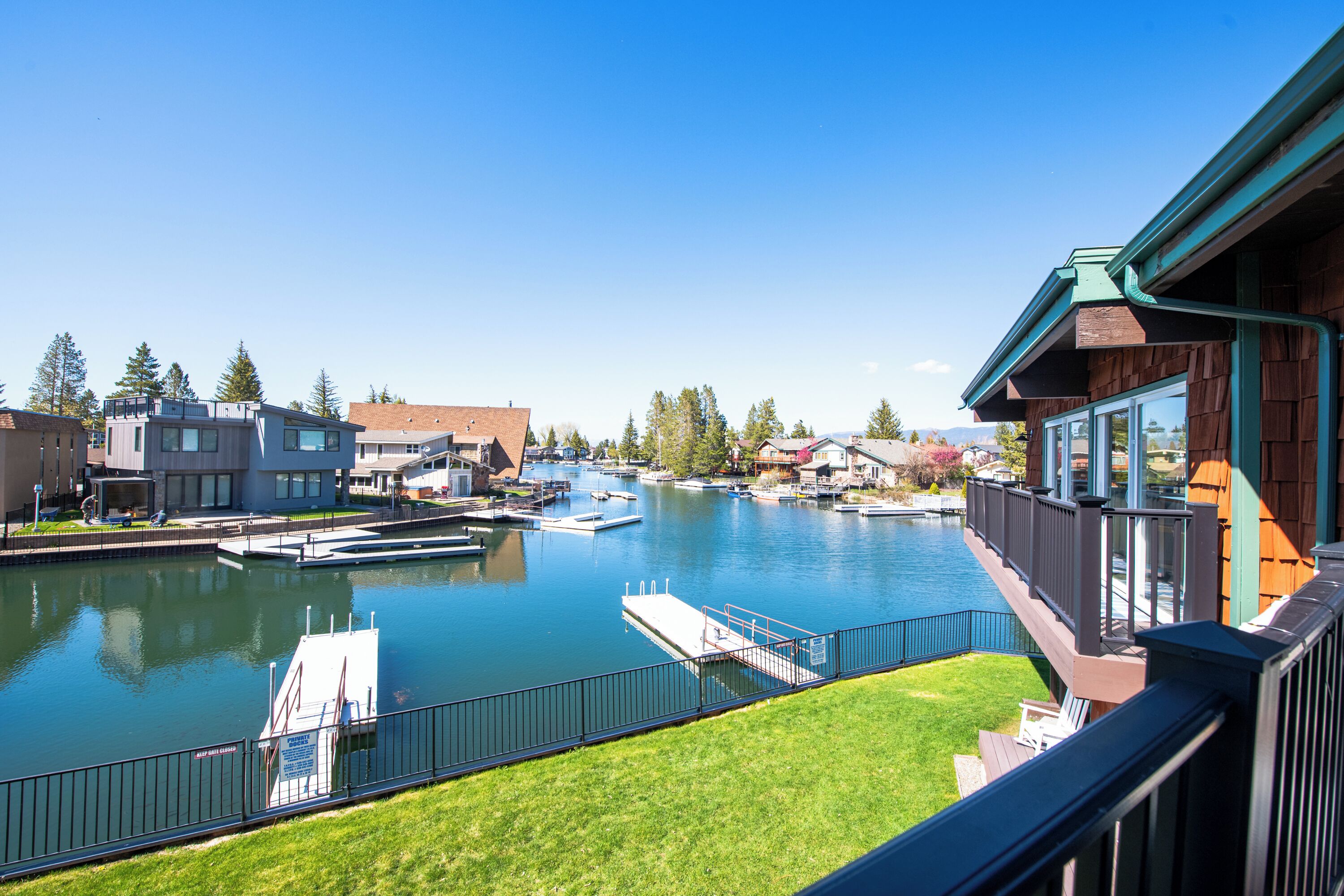 A riverside view with a dock, boats, and residential buildings.