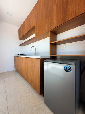 Cocina con armarios de madera, refrigerador de acero inoxidable y encimera.