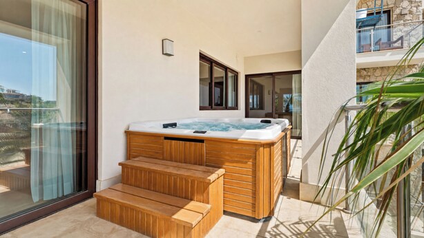 A hot tub with wooden steps and a glass door leading to a balcony. - Beachfront Luxury 3 BR Condo in Diamante Dunes (Cabo San Lucas)