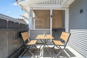 A small outdoor seating area with a table and two chairs, a potted plant, and a house number 329. - La Esperanza Unit B Cozy Central SD Retreat w/ A/C (National City)