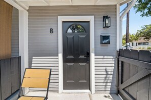 A front door with a mailbox, a bench, and a gated entrance. - La Esperanza Unit B Cozy Central SD Retreat w/ A/C (National City)