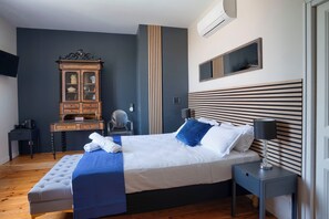 A modern bedroom with a large bed, bedside tables, a wardrobe, and a television. - Maison Bacchus 31 (Buzet-sur-Tarn)