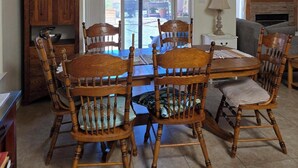 A dining area with a wooden table and chairs, a chandelier, and a view through a glass door to an outdoor patio. - Beautiful 3-bed house in Los Ranchos.  Balloon fiesta park is just minutes away. (Albuquerque)