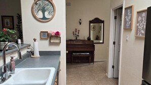 A kitchen with a sink, countertop, and a piano in the background. - Beautiful 3-bed house in Los Ranchos.  Balloon fiesta park is just minutes away. (Albuquerque)
