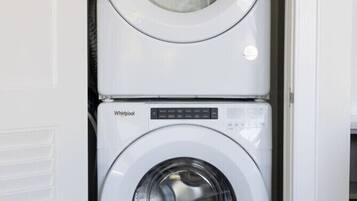 Une machine à laver et un sèche-linge superposés dans une buanderie.