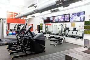 A gym with treadmills, elliptical machines, and free weights. - The Brent Lofts Palafox Penthouse (Pensacola)