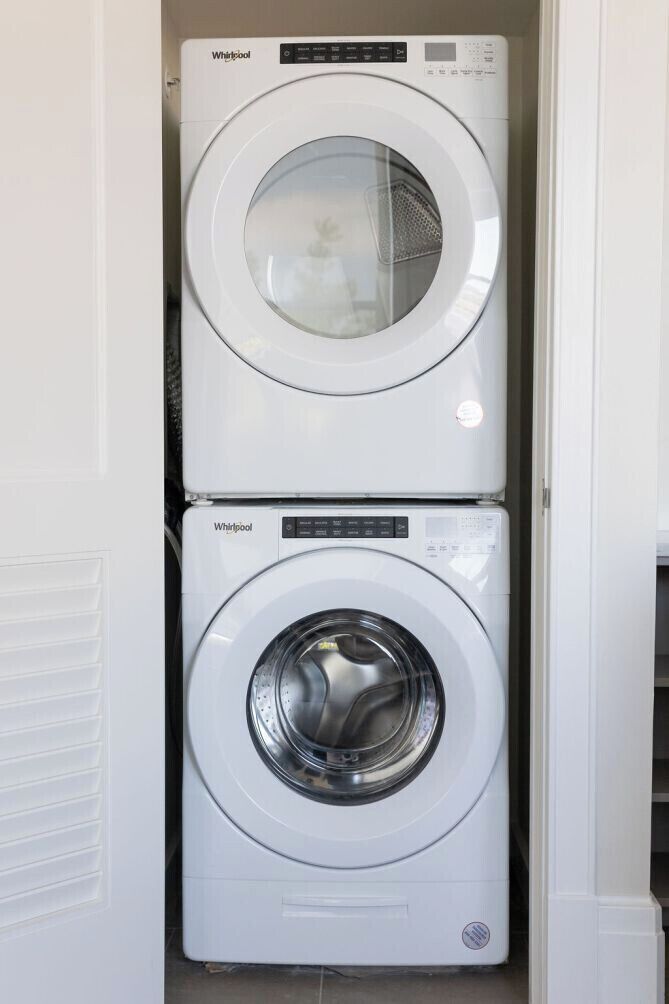A stacked washer and dryer unit in a laundry room.