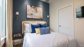 Ein Schlafzimmer mit einem Bett, einer Wanduhr und einem Gemälde.