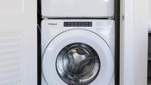 A stacked washer and dryer unit in a laundry room. - 2BR Palafox Oasis at the Brent Lofts (Pensacola)
