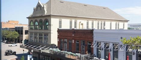 A building with a large arched window on the ground floor, a flat roof, and a brick facade.
