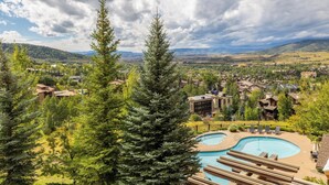 A resort with a pool area, surrounded by trees and buildings. - Edgemont Condominiums (Steamboat Springs)