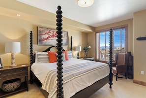 A four-poster bed with a view of a cityscape through large windows. - Edgemont Condominiums (Steamboat Springs)