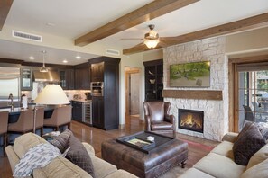 A spacious living area with a fireplace, a dining area, and a kitchen. - Edgemont Condominiums (Steamboat Springs)