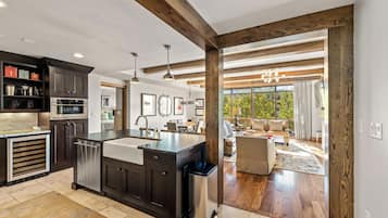 Una cocina moderna con armarios oscuros, una isla central y electrodomésticos de acero inoxidable.