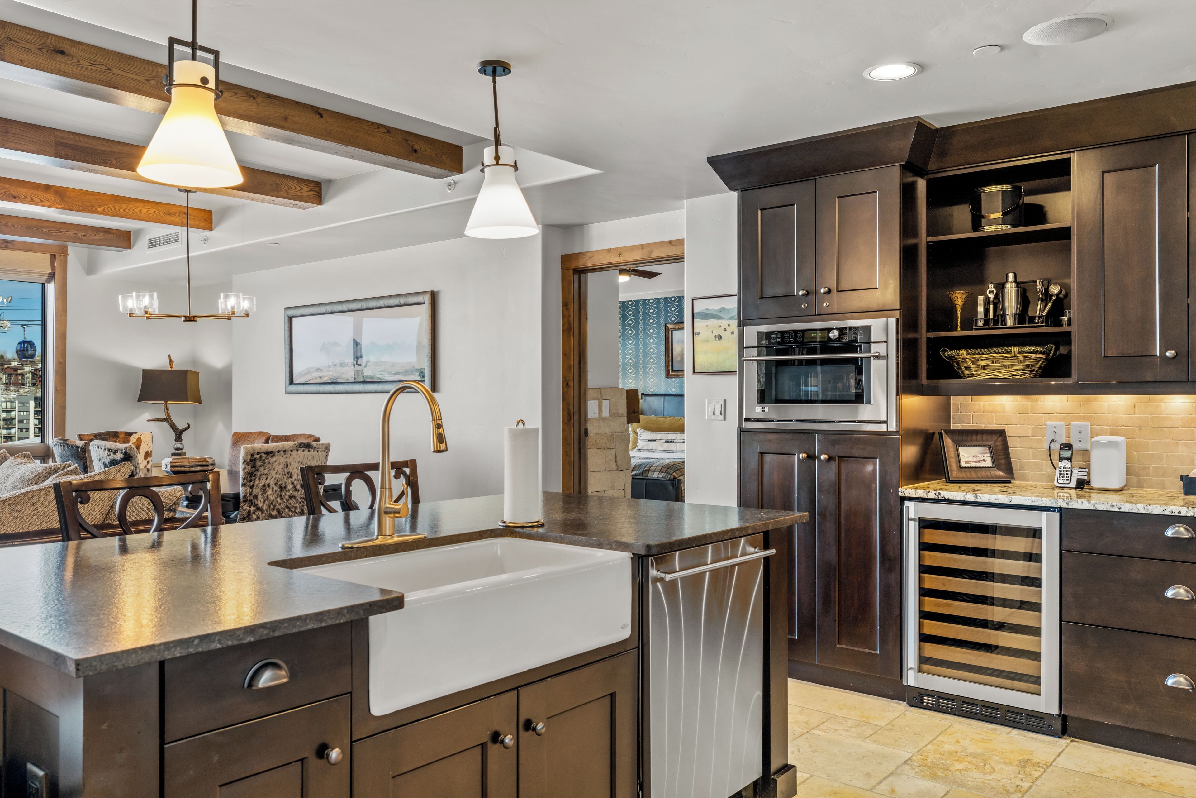 A modern kitchen with a large island, built-in oven, and stainless steel appliances.