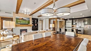 Un espacio habitable amplio con una gran mesa de comedor de madera, chimenea y cocina equipada con electrodomésticos modernos.