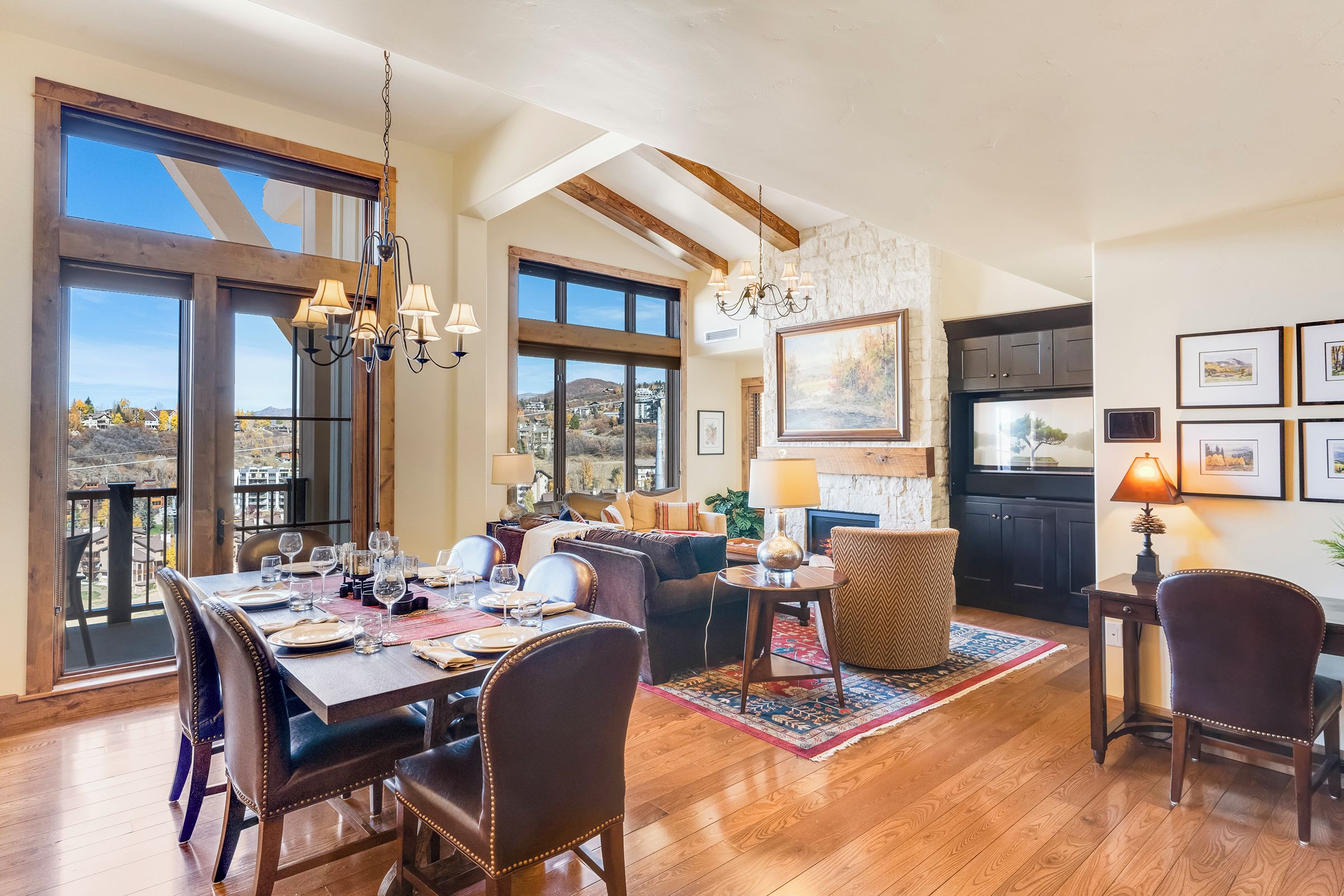 A spacious dining area with a high ceiling, large windows, and a view of the landscape.