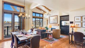 A spacious dining area with a high ceiling, large windows, and a view of the landscape.