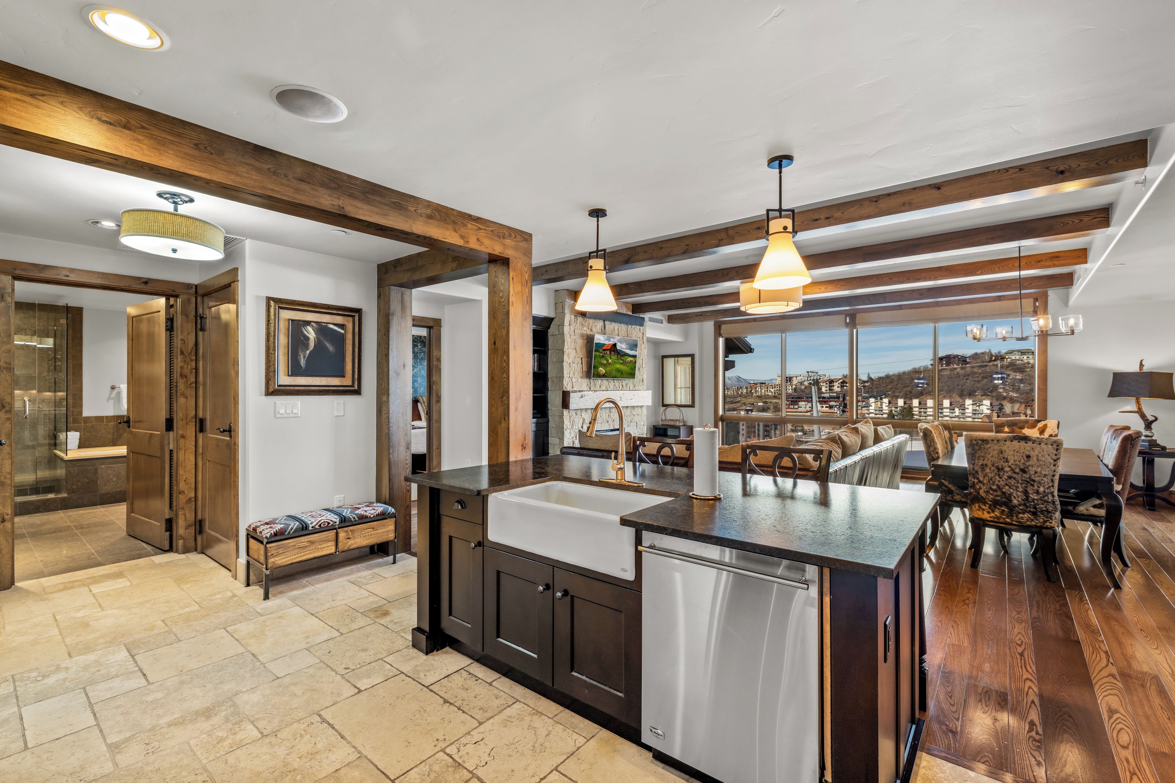 Una cocina moderna con una isla central, vigas de madera y vistas a la ciudad.