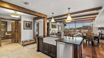 Una cocina moderna con una isla central, vigas de madera y vistas a la ciudad.