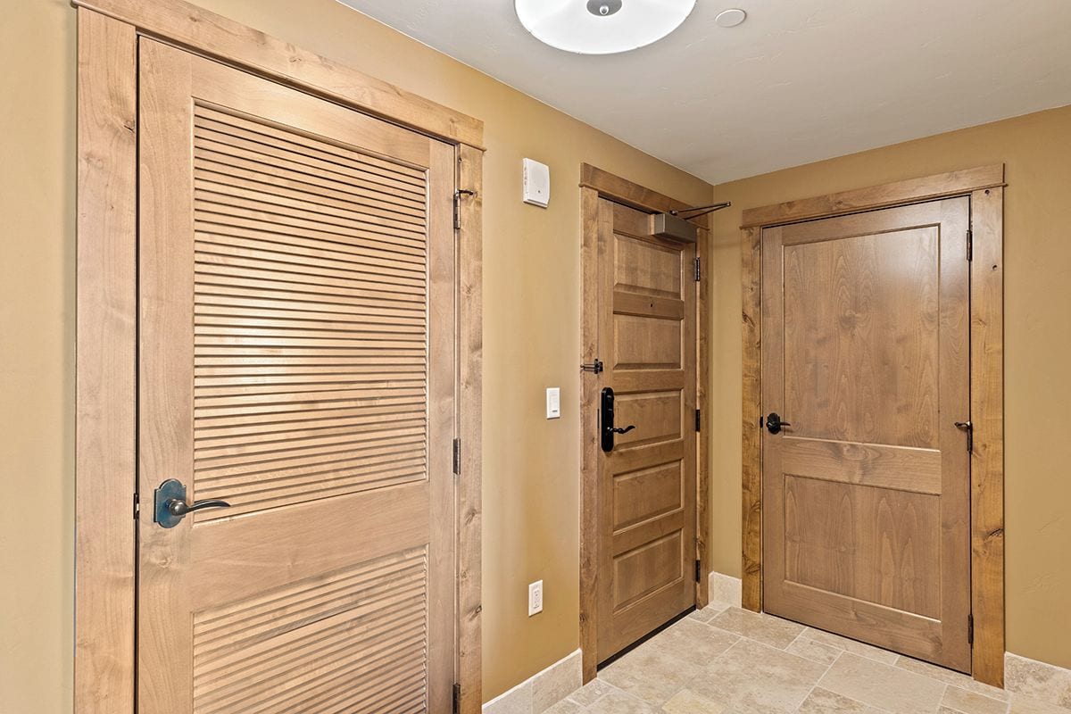 A hallway with wooden doors and a light fixture on the ceiling.