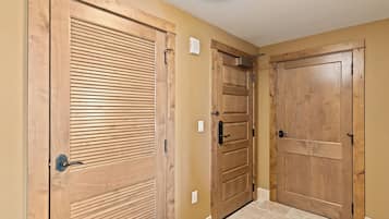 A hallway with wooden doors and a light fixture on the ceiling.