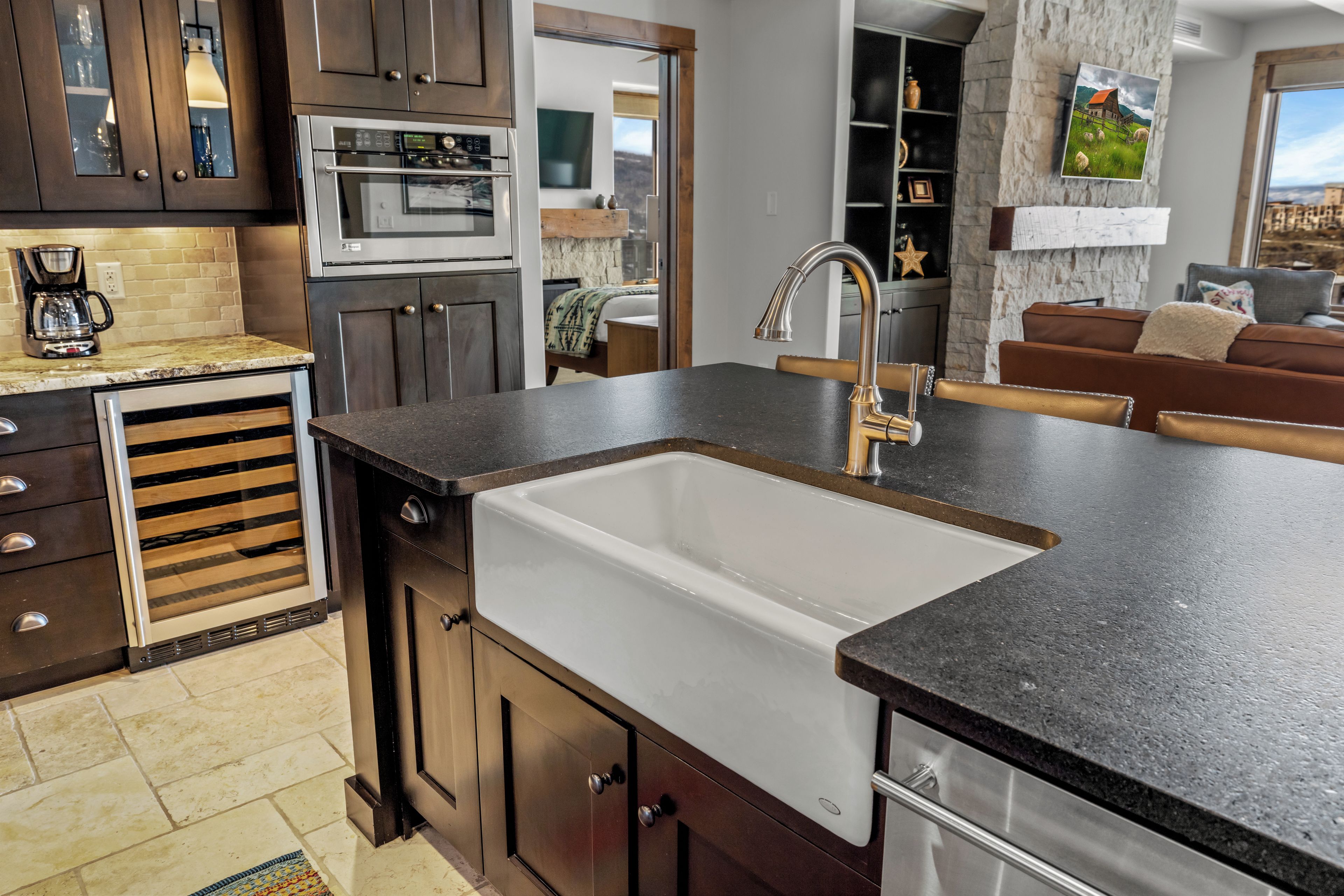 A modern kitchen with a built-in sink, stainless steel appliances, and dark cabinetry.