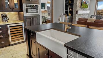 A modern kitchen with a built-in sink, stainless steel appliances, and dark cabinetry.