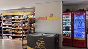 Zona de máquinas expendedoras con diversas opciones de bocadillos y bebidas, incluyendo un refrigerador de Coca-Cola y una máquina expendedora tipo refrigerador de metal.
