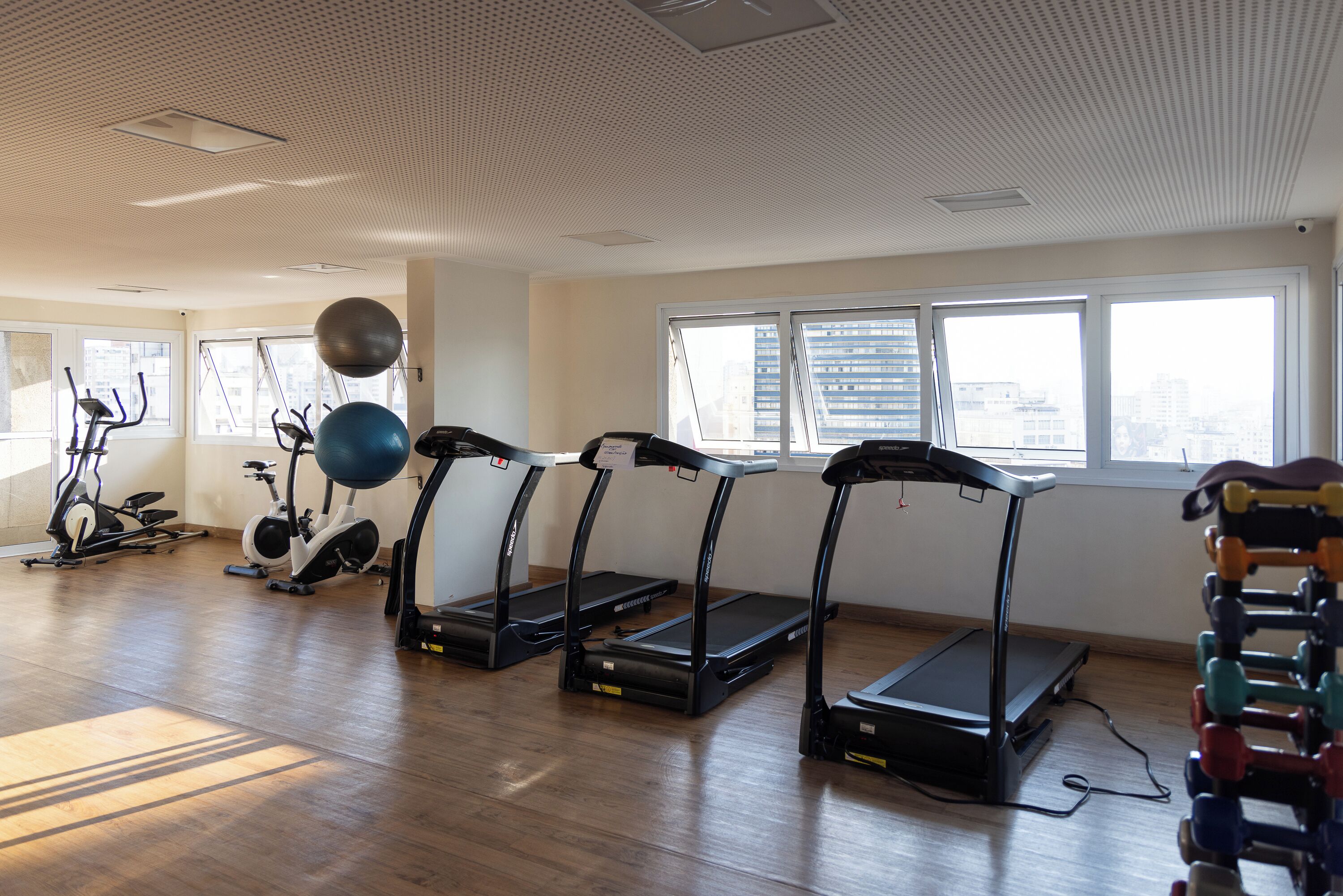 A gym with treadmills, exercise balls, and an elliptical machine.