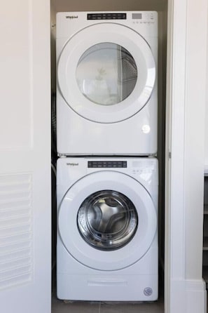 A stacked Whirlpool washer and dryer unit in a laundry room. - Modern Loft, Historic Streets- 2 bed/2 bath (Pensacola)