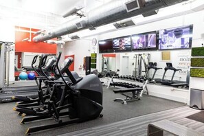 A gym with treadmills, elliptical machines, and weight benches. - Deja Blue Direct Street Access Condo (Pensacola)