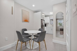 A modern kitchen with white cabinets, a stainless steel refrigerator, and a built-in oven. - Cozy-Luxe Jr 1BR Apt | Freshly Remodeled & Stylish (Miami Beach)