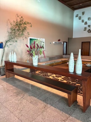 Um banco de madeira com um vaso de flores e vasos decorativos.