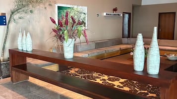 A wooden bench with a vase of flowers and decorative vases on it.