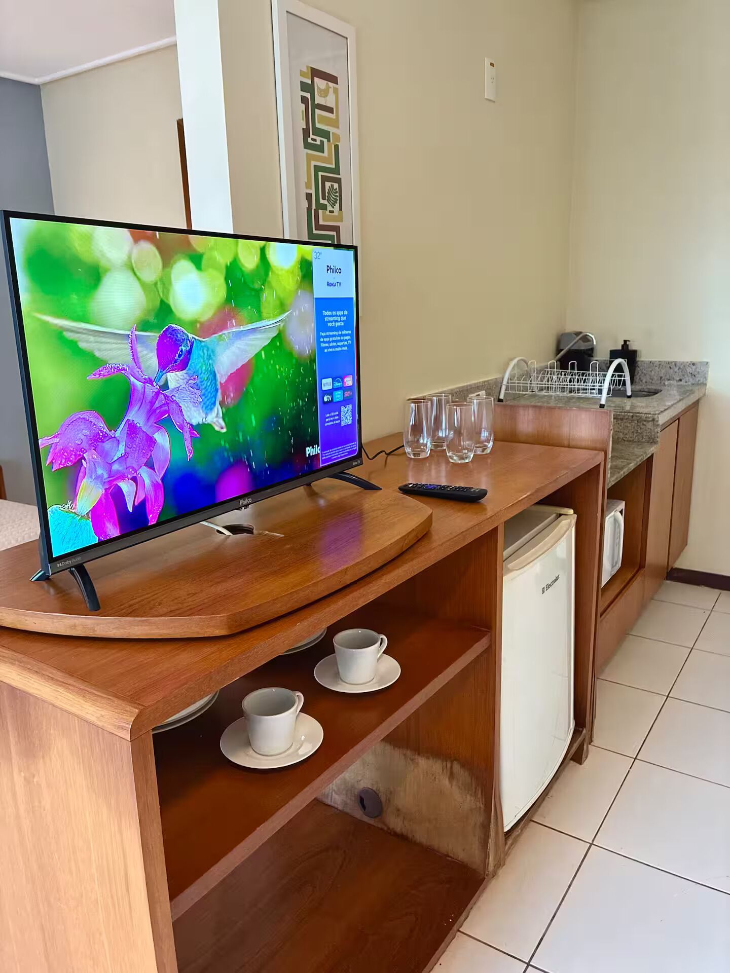 Uma cozinha moderna com televisão integrada, espaço para café e máquina de lavar louça.
