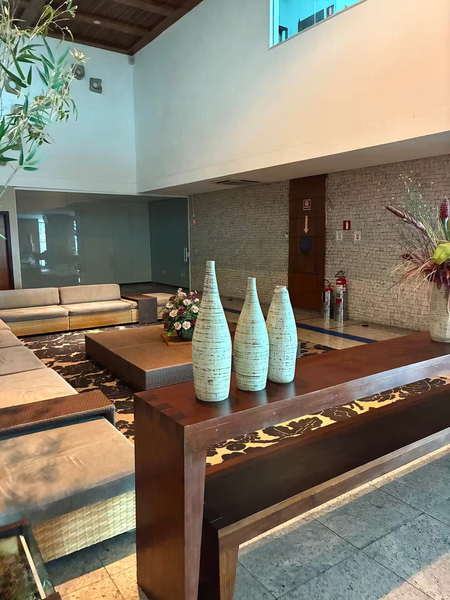 A reception area with a sofa, a wooden reception desk, and a brick wall.